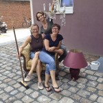 Drei Frauen sitzen gemeinsam auf einem Sessel, lachend